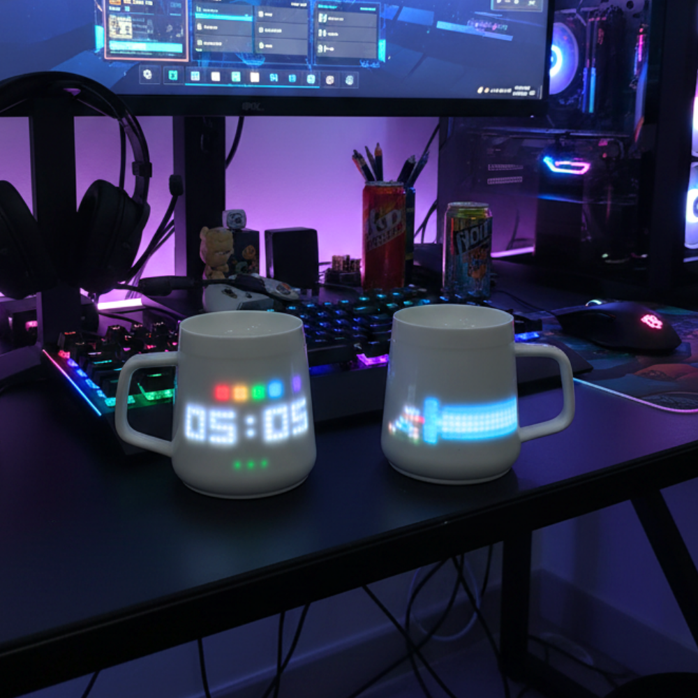 PixelMug P1 smart mugs with teal pixel display on a gaming desk setup with RGB keyboard and monitor.