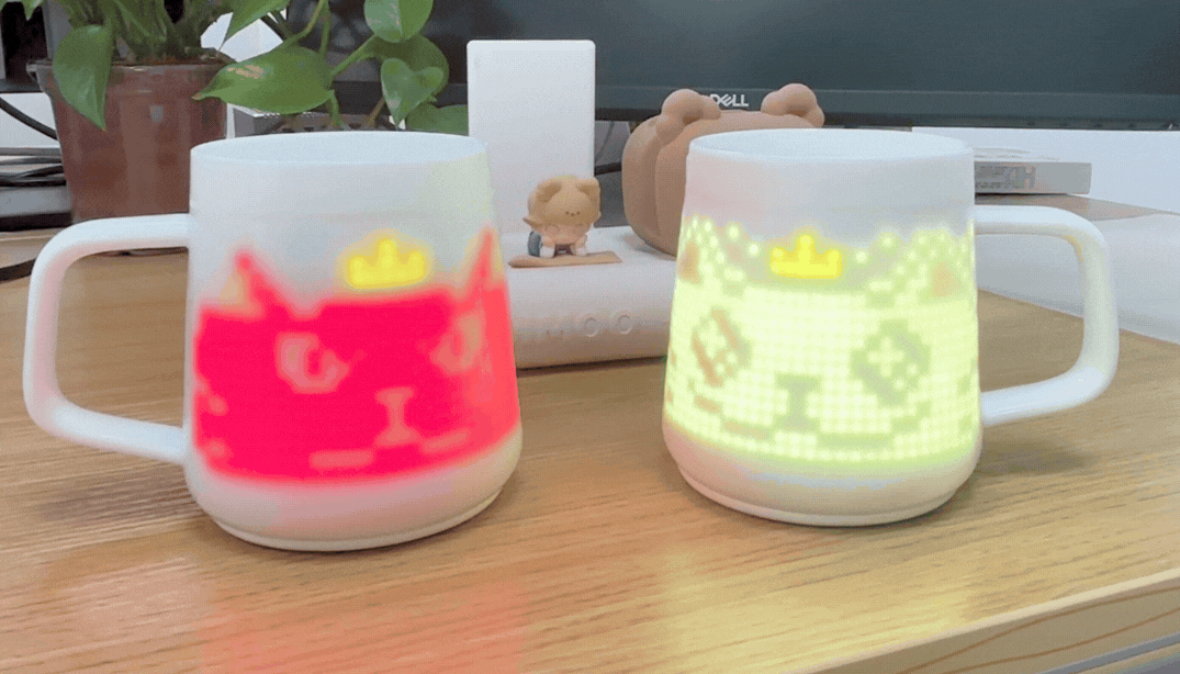 Two pixel mugs are placed on the desktop, displaying an animation of a pixelated cat wearing a crown.